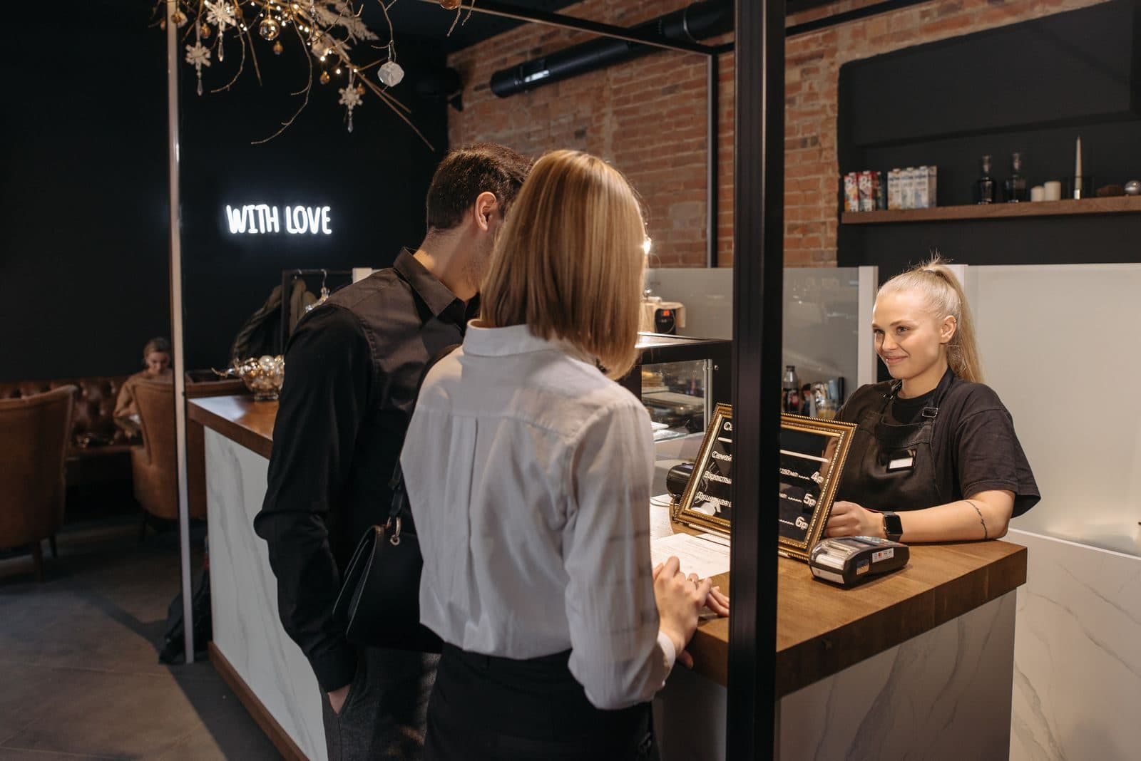 Staff member serving people at a café front counter