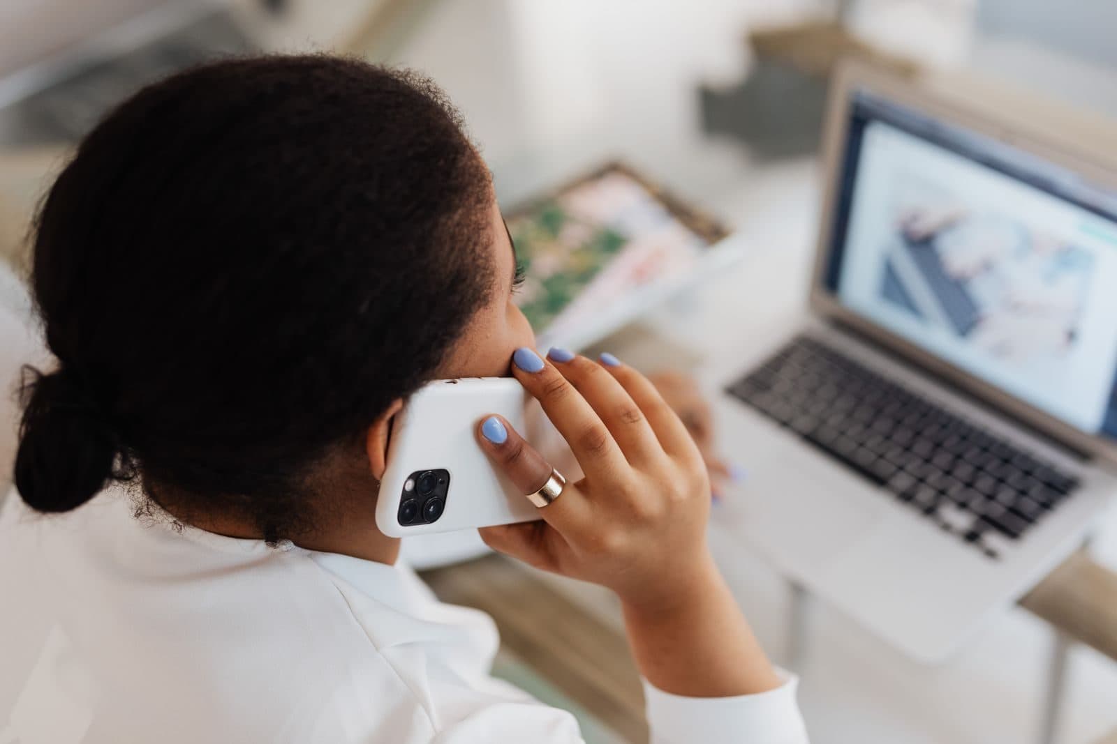 Person on a phone call while working at a laptop